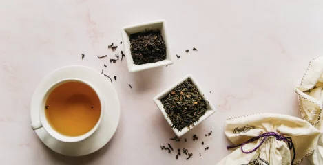 Evas Kräutertee am Tisch mit Kräuter in kleinen  schelchen