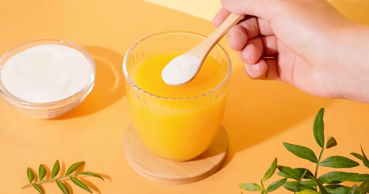 Natriumascorbat in Pulver Form und ein Glas mit Saft