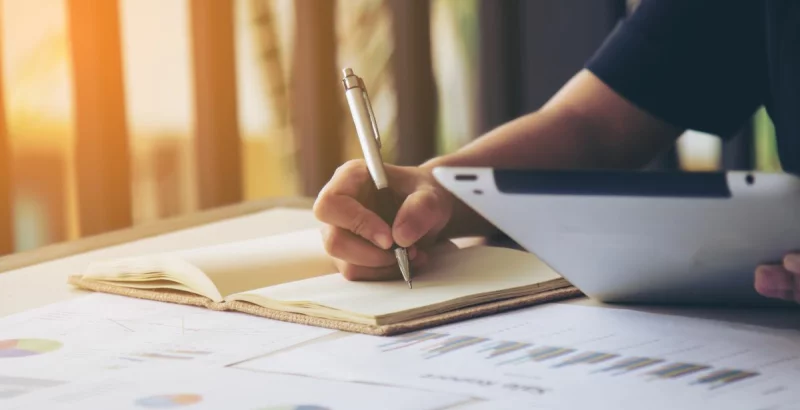 Ein Mann schreibt in ein Notizbuch.