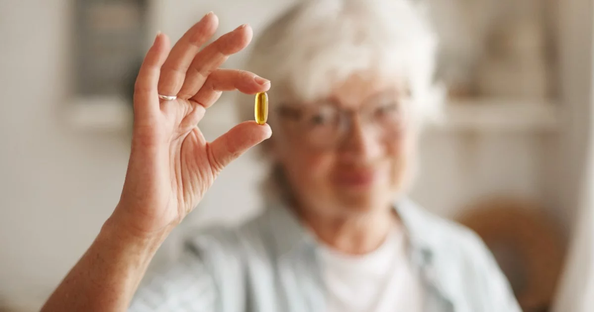 In der Hand wird eine Vitamin-D-Kapsel gehalten.