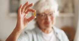 In der Hand wird eine Vitamin-D-Kapsel gehalten.