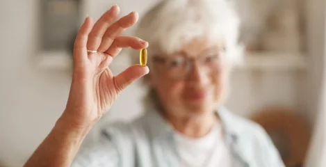 In der Hand wird eine Vitamin-D-Kapsel gehalten.