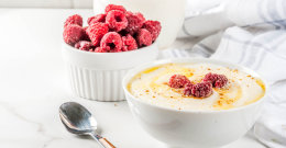 Grießbrei mit Milch mit einer Schüssel Himbeeren