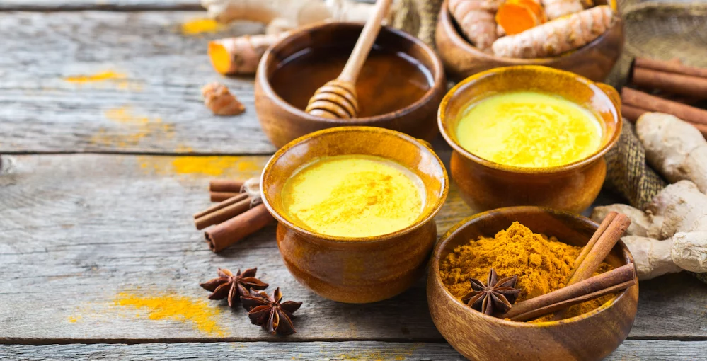 Goldene Milch, Honig und Kurkuma Pulver am Tisch